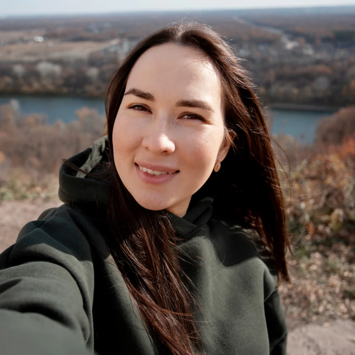 Image of a smiling woman in a green jacket, representing the compassionate care and holistic approach to mental health in rehabilitation at Addiction Resource Center LLC.
