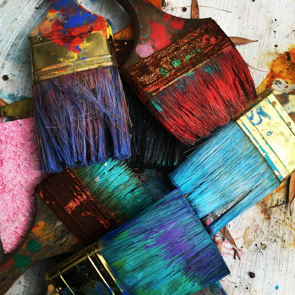 A person painting on canvas in a calm therapy setting, using expressive brushstrokes to process emotion